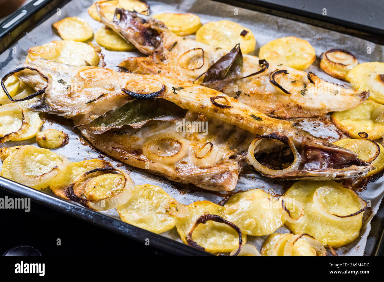 Filet de Loup Grillé à pommes de terre et les oignons dans la plaque de  cuisson avec un four. L'alimentation biologique. Les fruits de mer Photo  Stock - Alamy