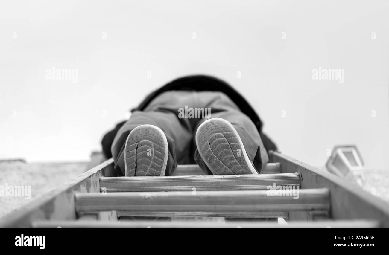 Low angle view of a handyman grimper sur une échelle d'acier. Banque D'Images