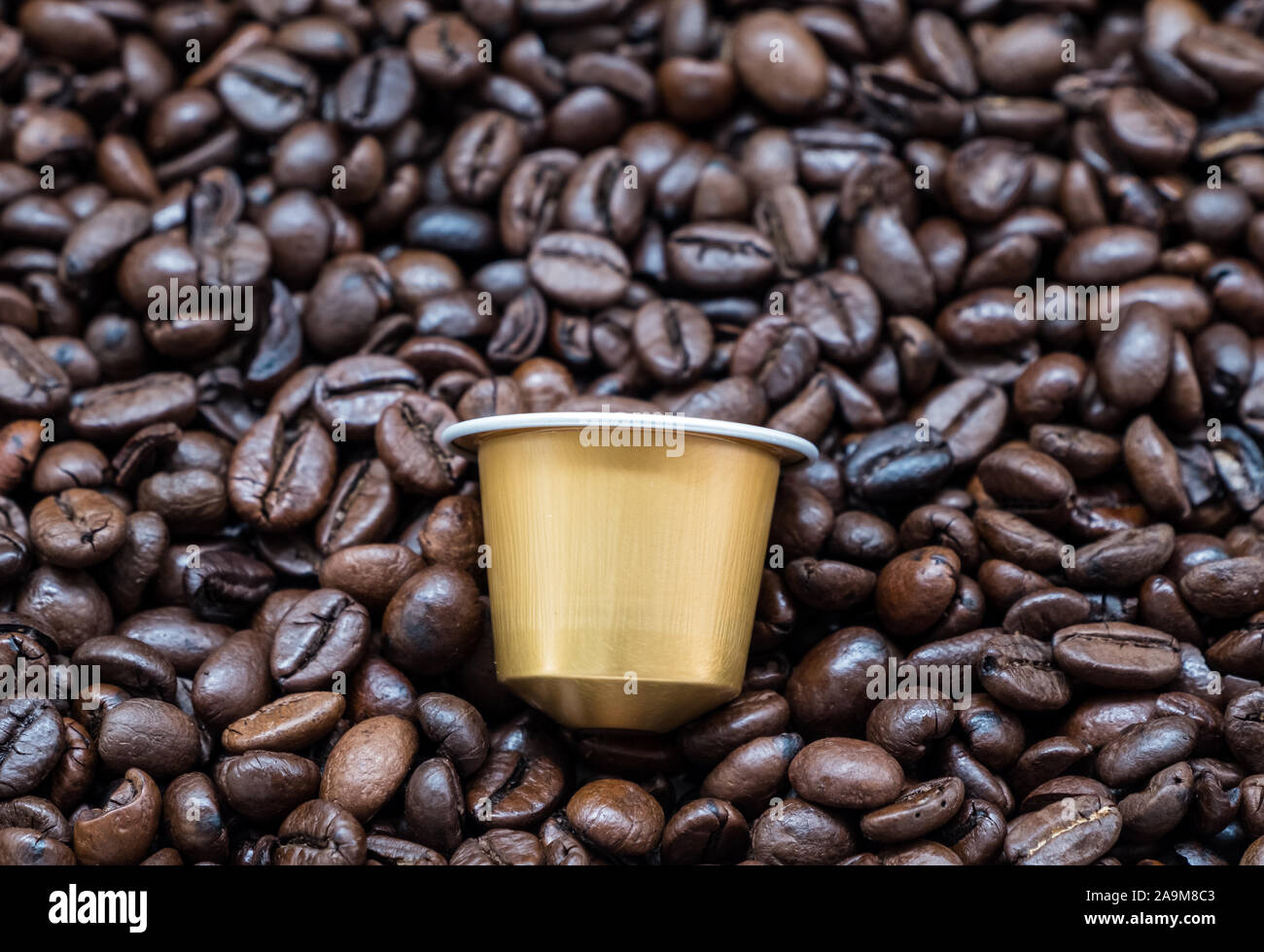 Capsule de café doré sur le grain de café torréfié foncé pour l'utilisation  de la machine Nespresso,(copie espace Photo Stock - Alamy