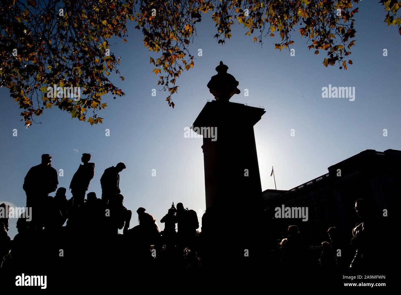 Silhouettes de personnes debout sur le mur pour assister à la relève de la garde au Palais de Buckingham à Londres Banque D'Images