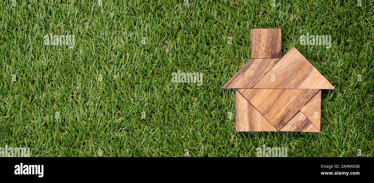 Portrait d'en-tête Tangram Accueil forme sur fond d'herbe verte artificielle Banque D'Images