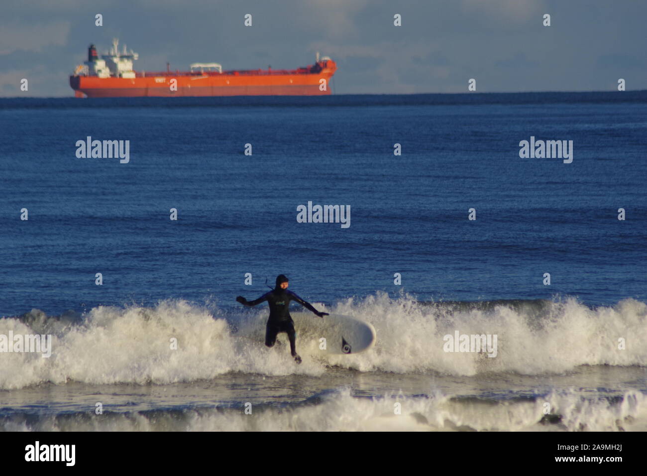 L'élimination de surf sur une vague, sur une Soirée hivers. Mer du Nord, Aberdeen, Écosse, Royaume-Uni. Banque D'Images
