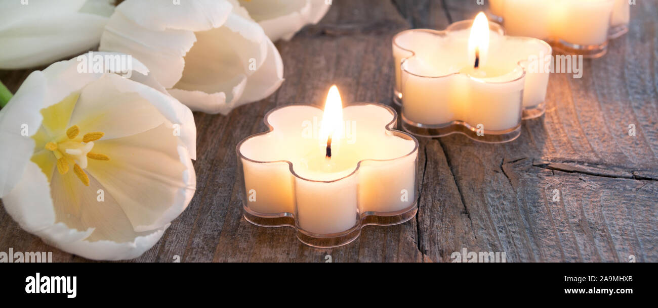 Décoration de pâques bougies avec tulipes blanches sur fond de bois Banque D'Images