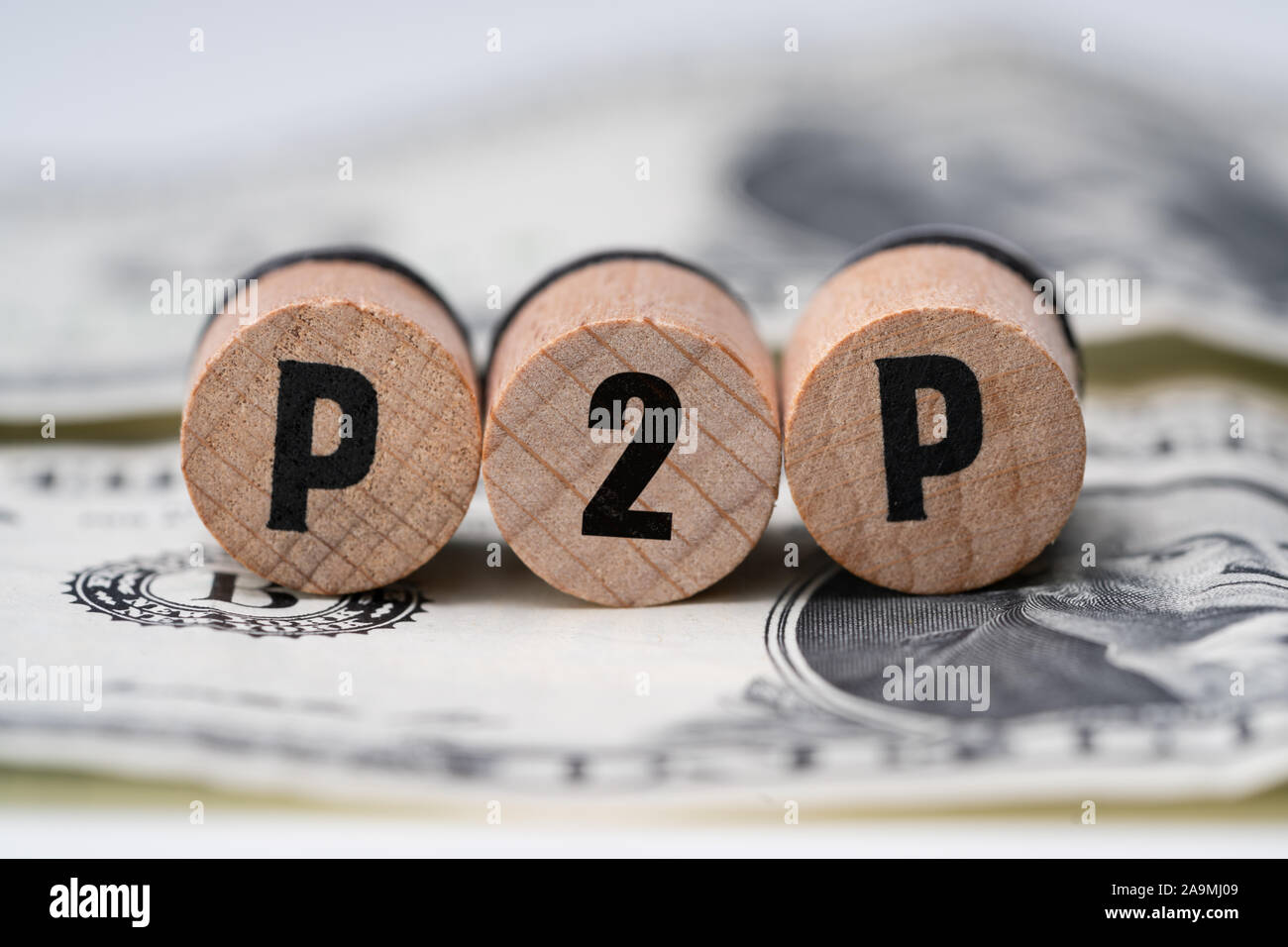 Close-up of A P2p mot sur des blocs de bois rond sur Dollar Bill Banque D'Images