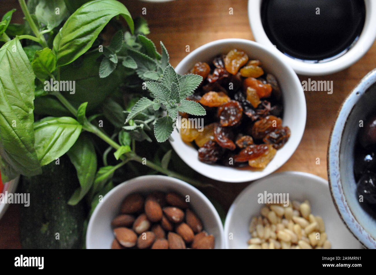 Les herbes, les raisins secs, les noix, les olives de dessus dans de petits bols en céramique Banque D'Images