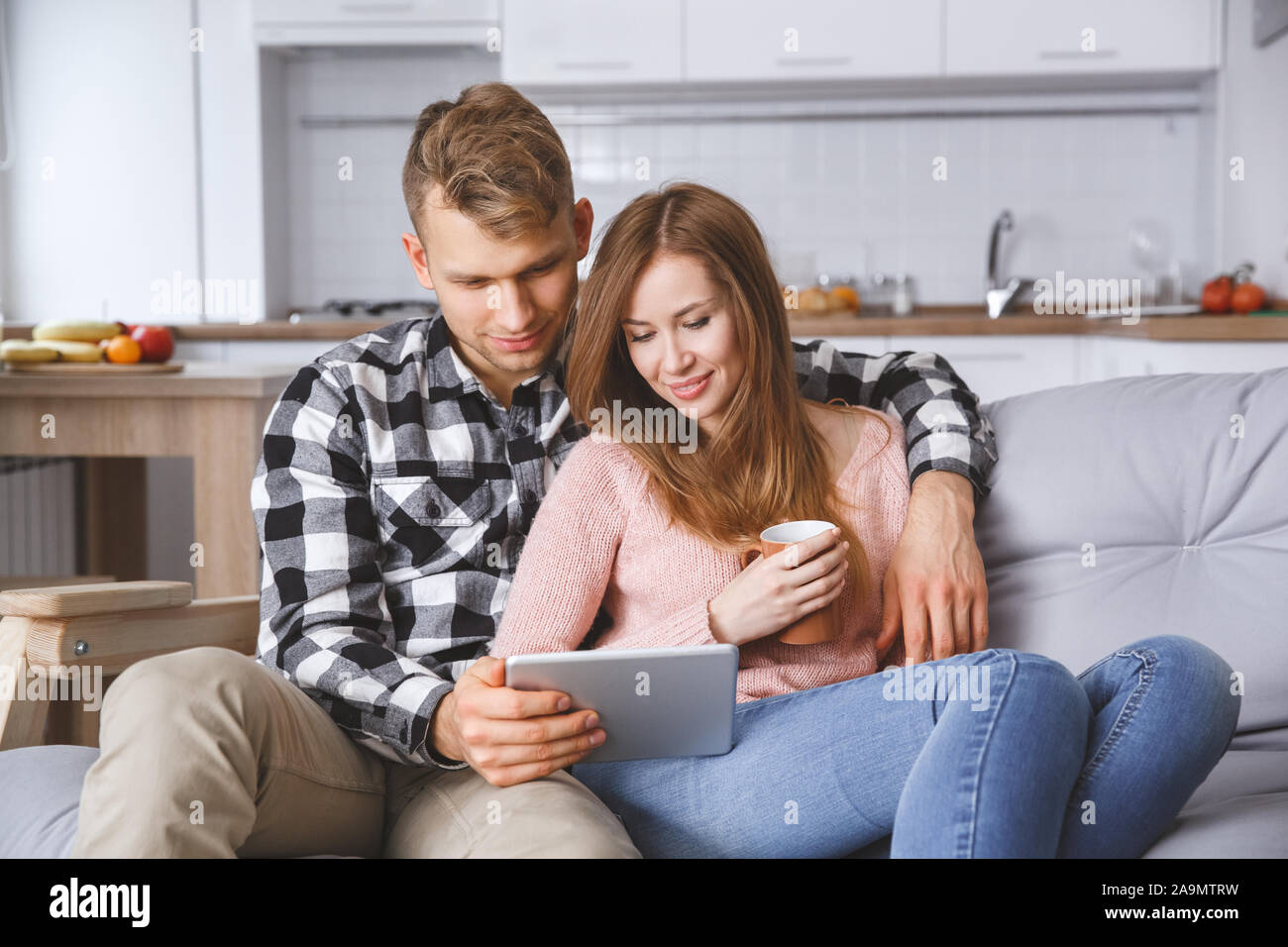 Jeune couple ensemble à l'amour accueil concept regardant la vidéo Banque D'Images