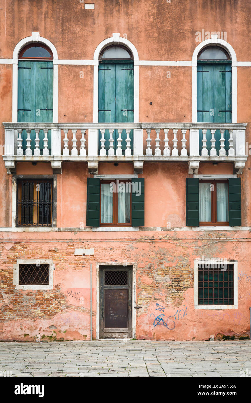 Venise, Italie - le 23 décembre 2012. Face d'une maison de ville ancienne avec des murs en détresse et de vieux volets en bois Banque D'Images