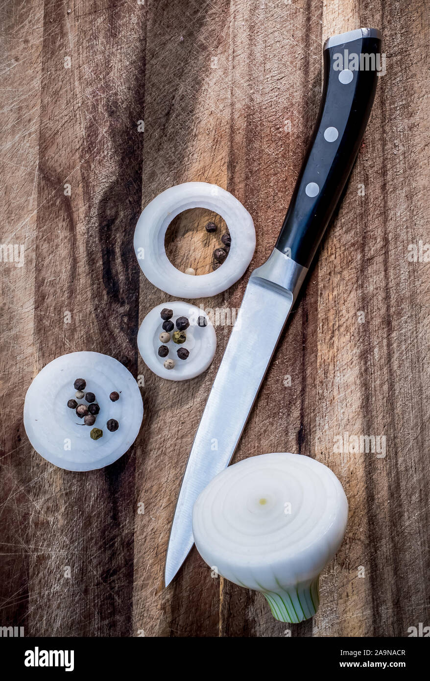 Couteau et l'oignon et le poivron sur planche de bois Banque D'Images