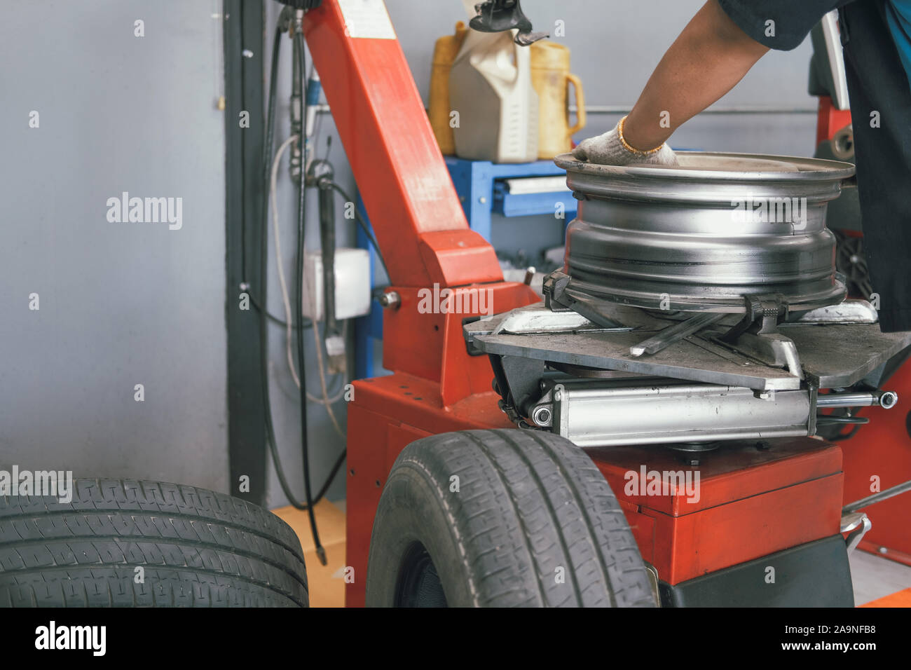 Retrait de caoutchouc technicien location de roues et pneus équilibrage sur balancer in auto repair shop garage Banque D'Images
