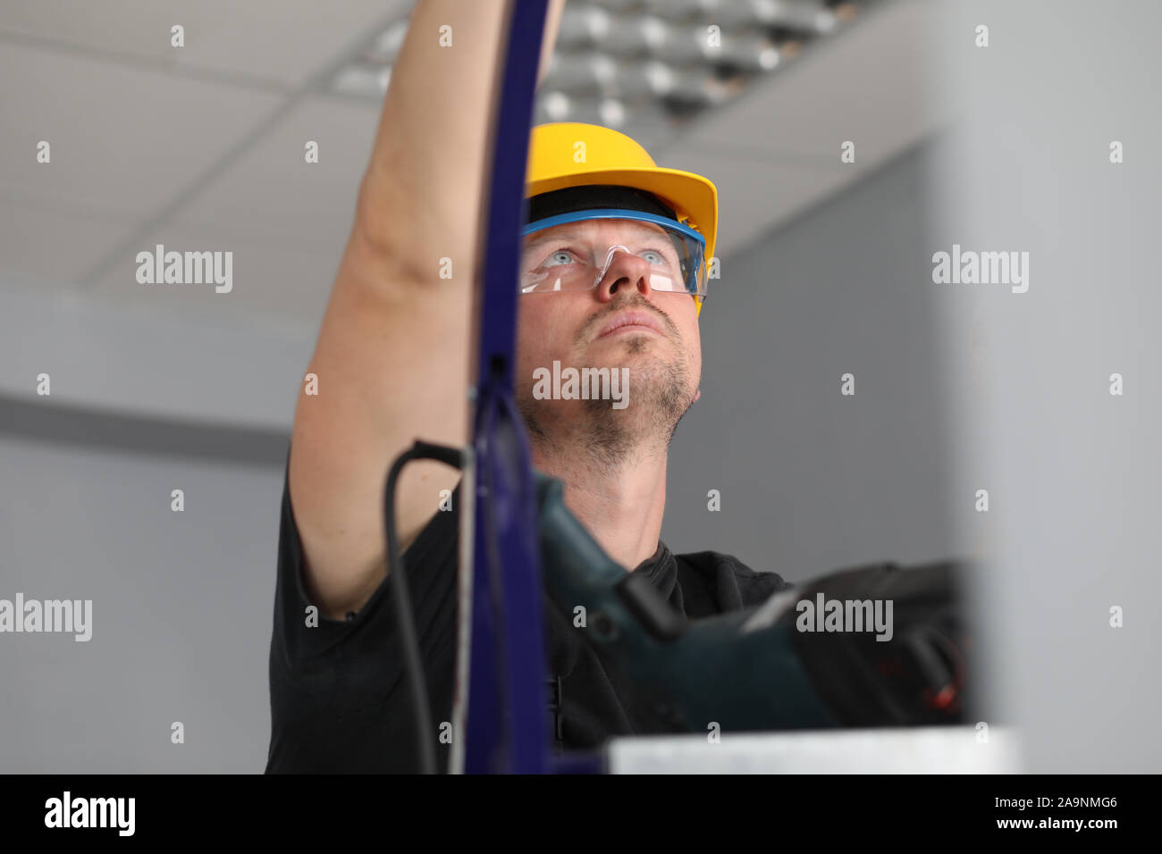 Workman sur l'échelle au travail Banque D'Images