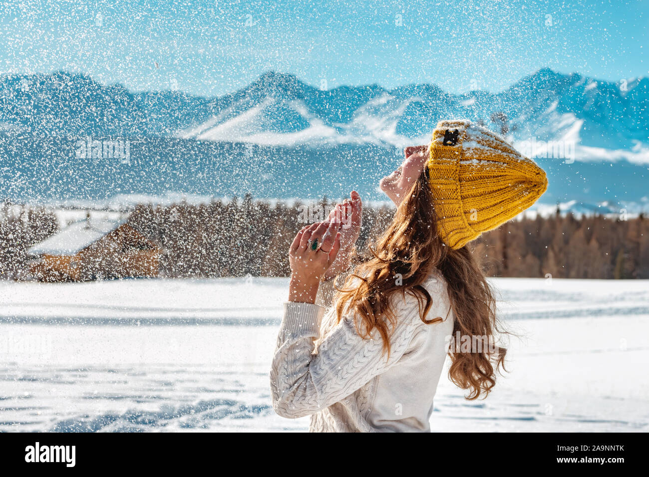 Jeune fille est heureux de jouer et de lancer la neige contre montagne Banque D'Images
