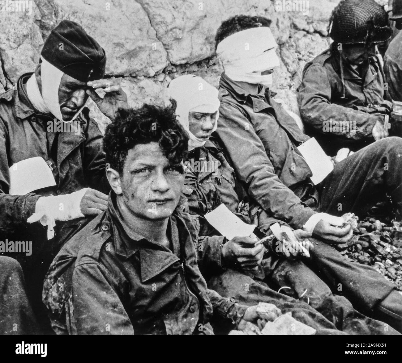 [CAPTION] l'origine un groupe de soldats américains qui, bien que blessé, d'assaut le pont et gagné la relative sécurité de Chalk cliffs à leur dos. La nourriture et les cigarettes ont été disponible pour prêter confort aux hommes. Omaha Beach, Normandie, France. 3e bat., 16ème Inf. Regt., 1re-NOUS INF. Div., Collville Sur Mer, 6 juin 1944 Banque D'Images
