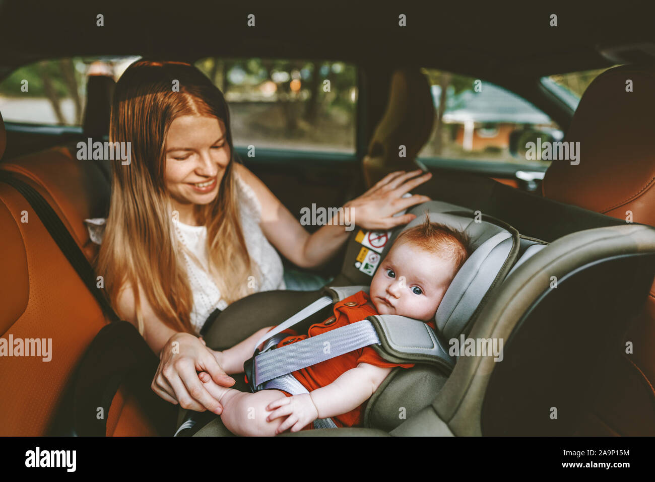 Mère et bébé en voiture enfant assis dans le siège de la sécurité de vie de famille heureuse vacances voyage routier location auto transport orienté vers l'arrière Banque D'Images