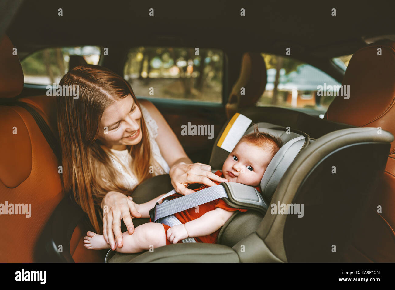 Mère et bébé en voiture de vie familial enfant assis dans le siège de la voiture de sécurité enfant vacances face à l'arrière transport Banque D'Images