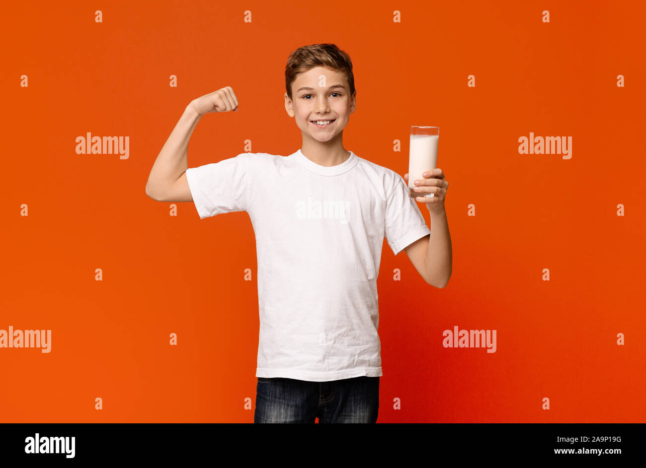 Cheerful woman démontrant biceps après boire du lait Banque D'Images