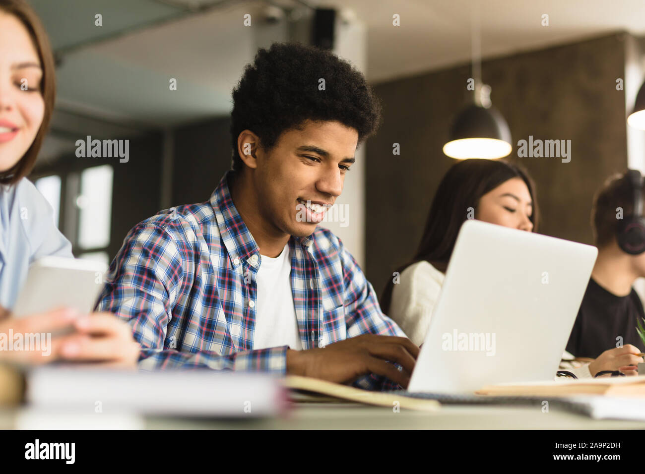 Male student with laptop étudiant dans la bibliothèque de l'université Banque D'Images