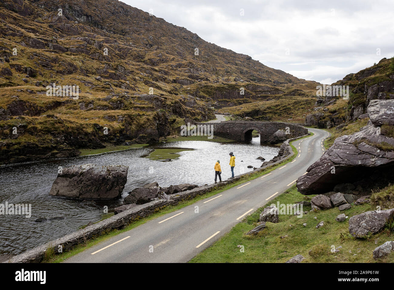 Mère et fils marcher par la rivière Loe, petite route à travers la vallée de Gap of Dunloe Macgillycuddy Reeks dans les montagnes, l'Irlande, le comté de Kerry. Banque D'Images