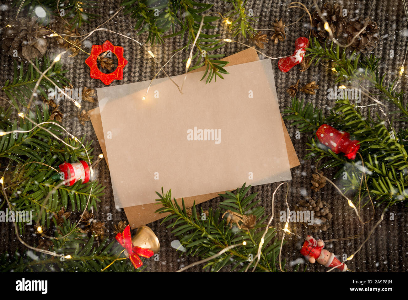Le papier blanc pour écrire une lettre au Père Noël. Fond sombre d'une  écharpe en tricot avec une guirlande lumineuse Photo Stock - Alamy