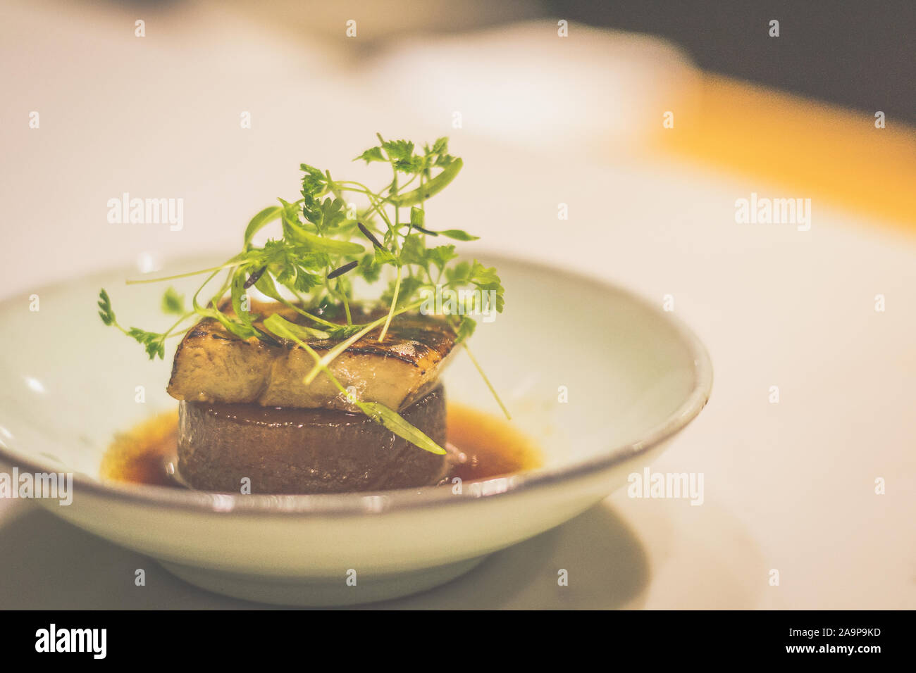 Daikon braisé de foie gras de canard dans un bol en porcelaine Banque D'Images