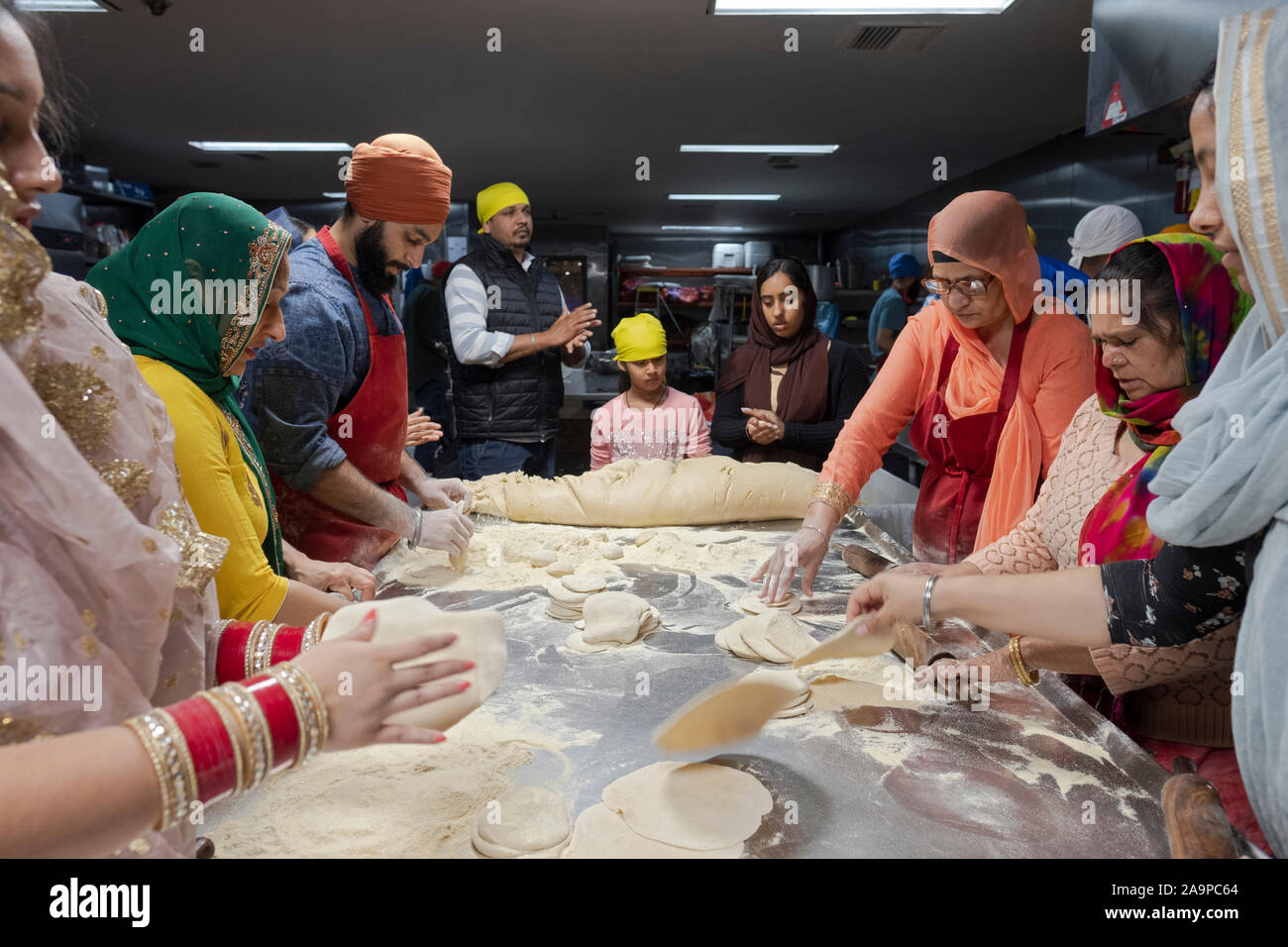 Les hommes sikhs et les femmes de tous âges préparer pains roti dans un  langar, une cuisine commune. Dans la région de South Richmond Hill, Queens,  New York Photo Stock - Alamy