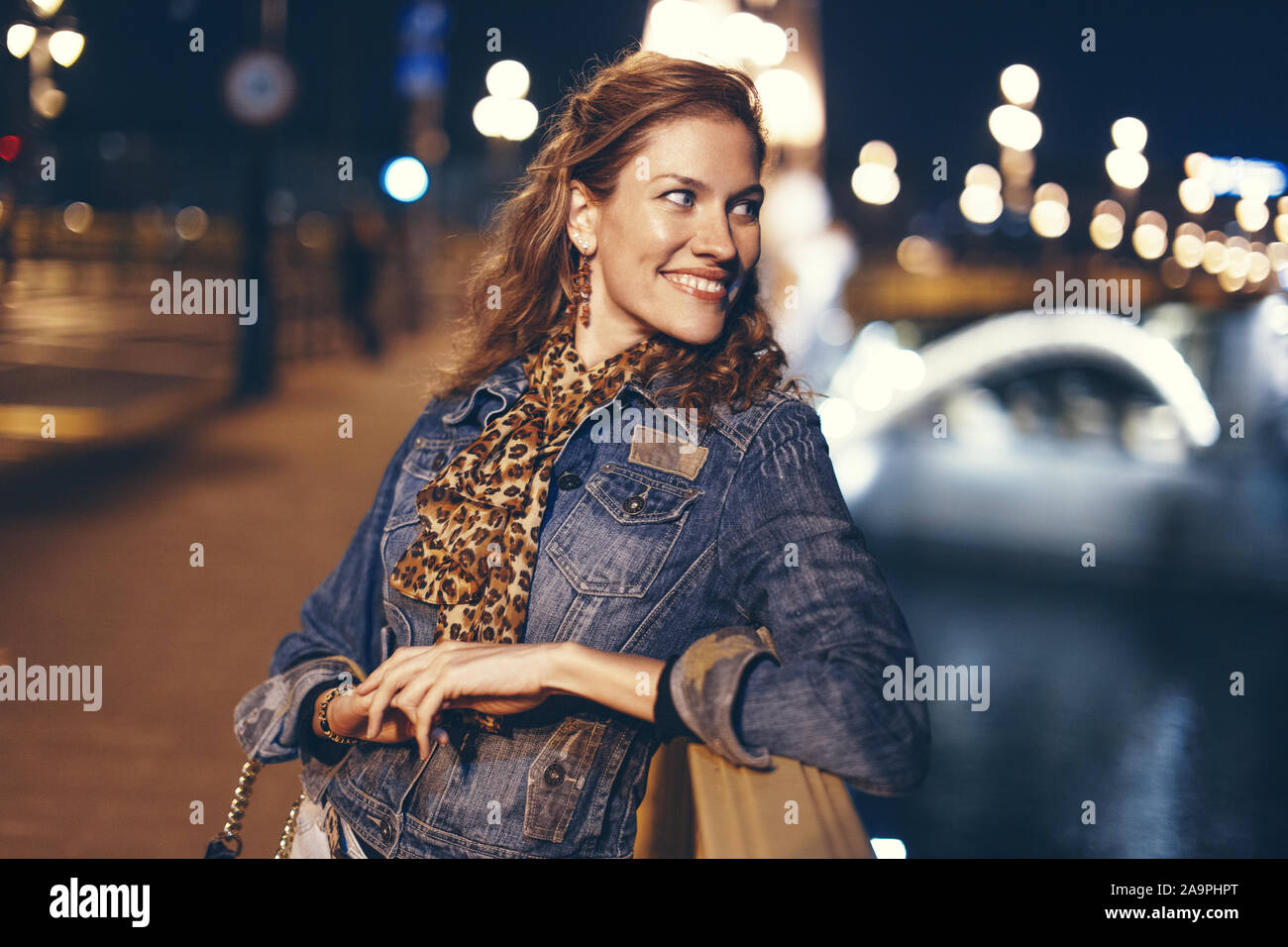 Happy young woman smiling urbaine et à l'écart sur bridge at night, Budapest, Hongrie Banque D'Images