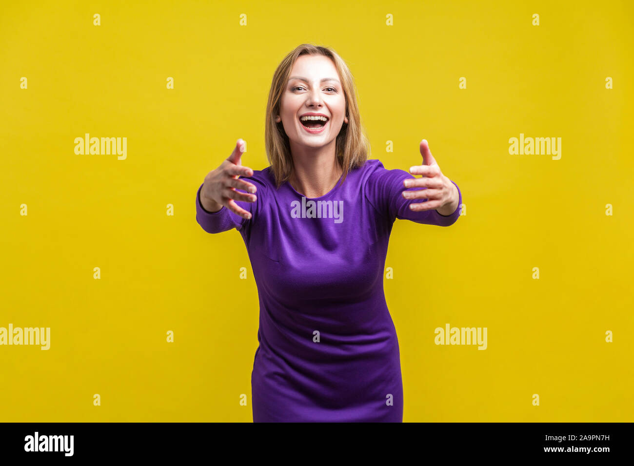 Viens dans mes bras, free hugs ! Portrait de femme en accueillant adorable serré élégante robe pourpre de sourire et de toucher les mains, aller à l'embrasser. Banque D'Images