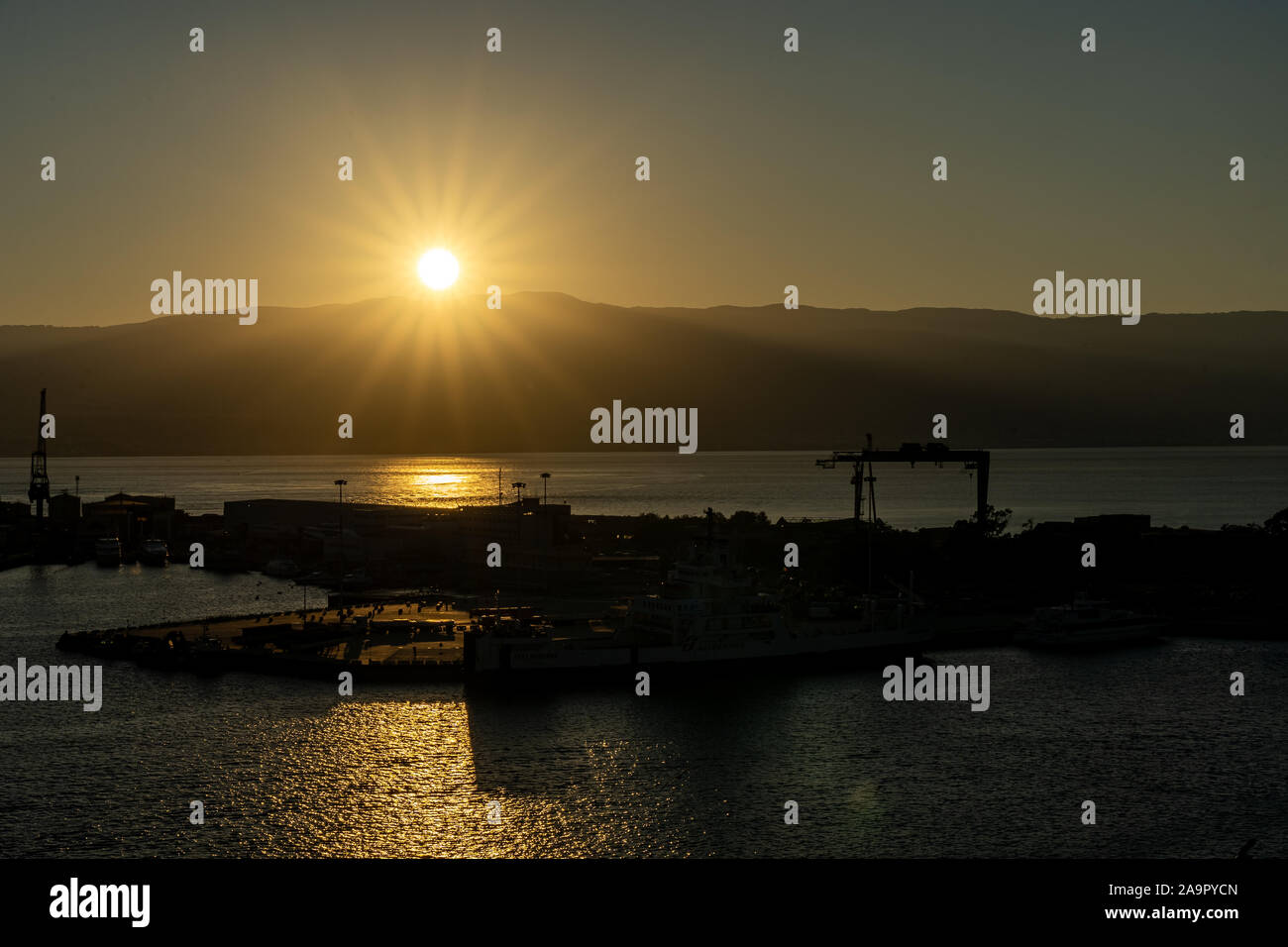 Lever du soleil au port de Messine avec soleil au-dessus des montagnes de Calabre, Italie Banque D'Images