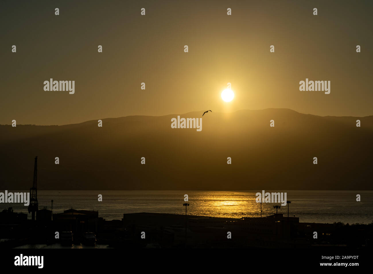 Lever du soleil au port de Messine avec soleil au-dessus des montagnes de Calabre, Italie Banque D'Images