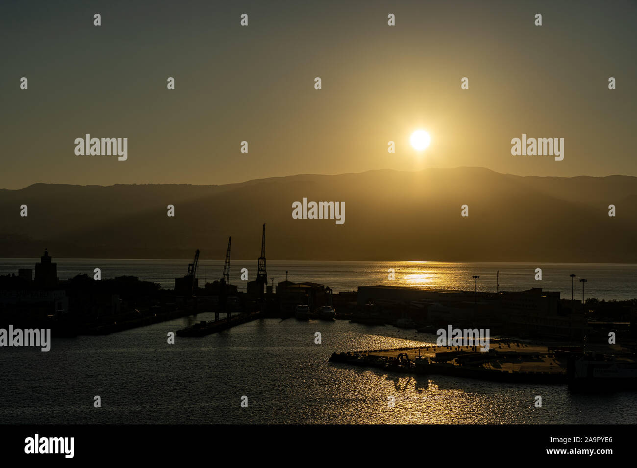 Lever du soleil au port de Messine avec soleil au-dessus des montagnes de Calabre, Italie Banque D'Images