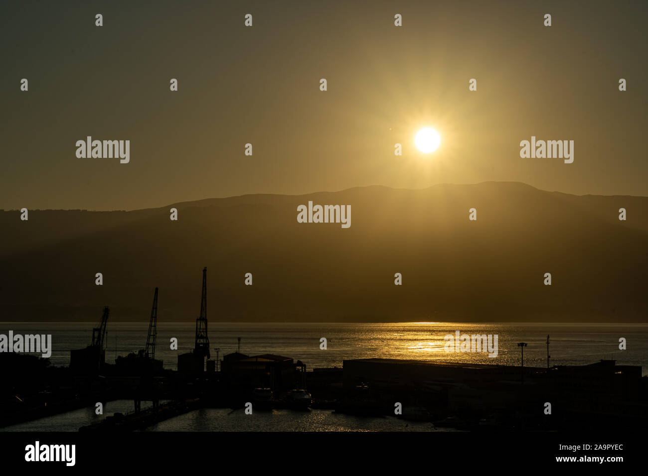 Lever du soleil au port de Messine avec soleil au-dessus des montagnes de Calabre, Italie Banque D'Images
