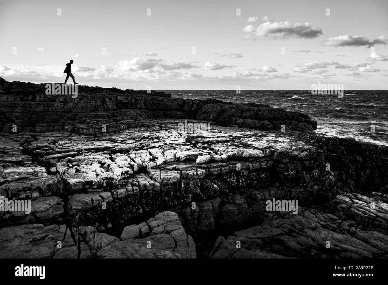 Soirée panoramique panoramique d'hiver sur la côte de la mer Adriatique à Polignano a Mare, Province de Bari, Pouilles, Italie du sud. Image en noir et blanc. Banque D'Images