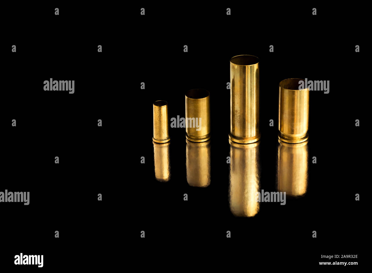 Comparaison de différentes tailles d'utilisé des obus sur une balle de fond isolé noir avec la réflexion d'une tin de table. Perception de la qualité Banque D'Images