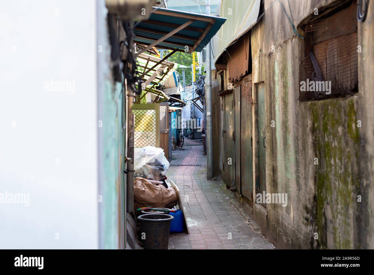 Ruelle étroite dans les bidonvilles. Quartier pauvre. De vie marginal. Les ordures, les choses anciennes et les vélos dans la région où vivent les gens riches pas Banque D'Images