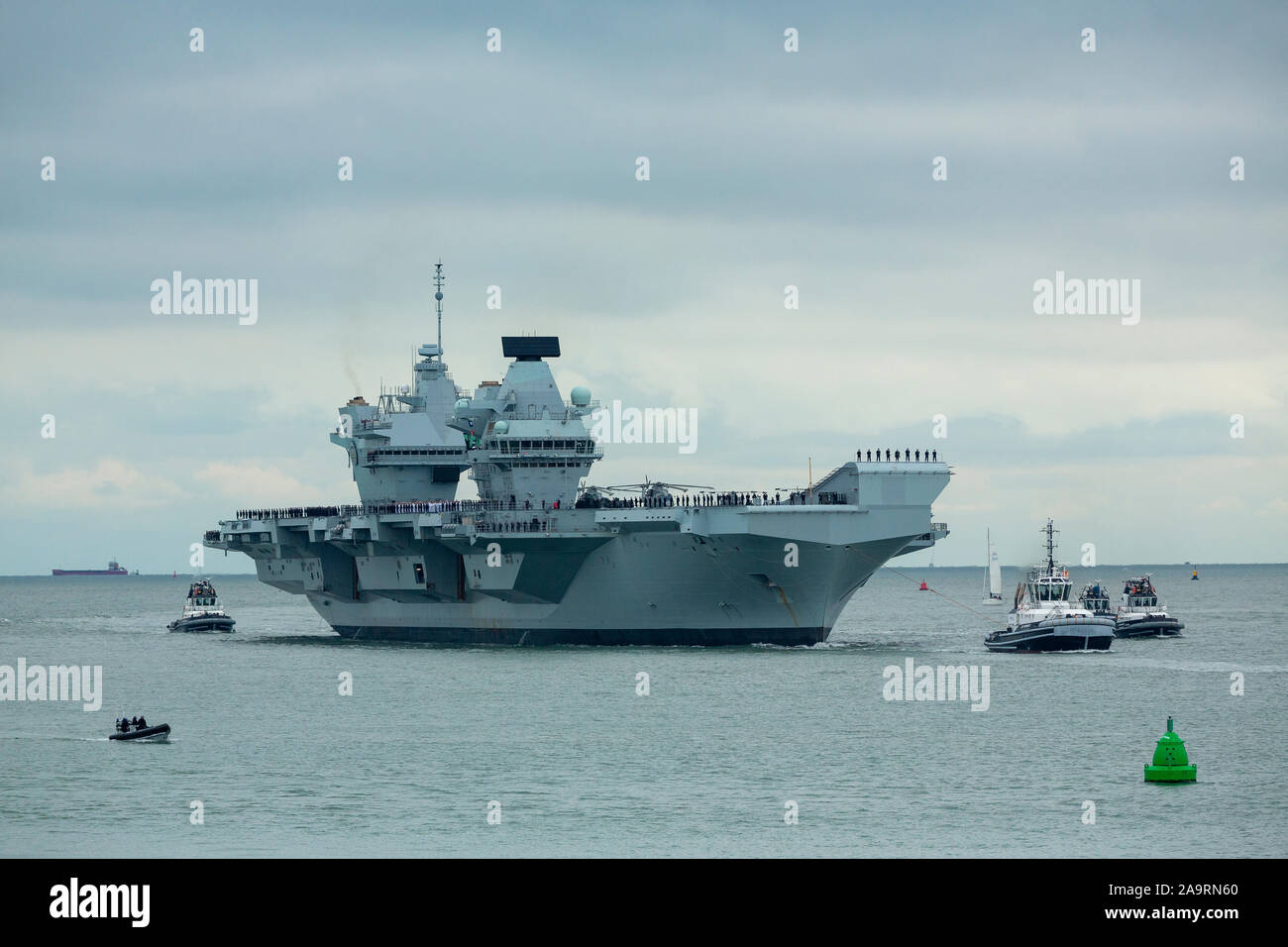HMS Prince de Galles arrivant à Portsmouth sa nouvelle maison. La foule recueillie par une froide après-midi de novembre pour accueillir le navire de guerre massive. Banque D'Images