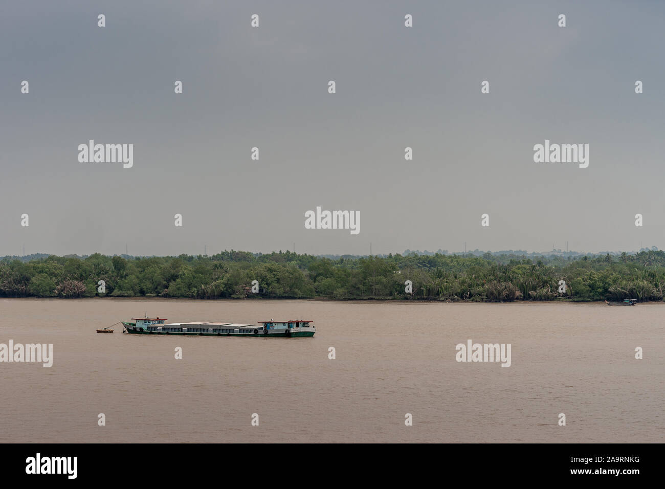 Tau Long River, au Vietnam - 12 mars 2019 : Long River Barge coque segmentée voiles sur l'eau brune et se trouve profondément. Ceinture verte se sépare de ciel bleu... Banque D'Images