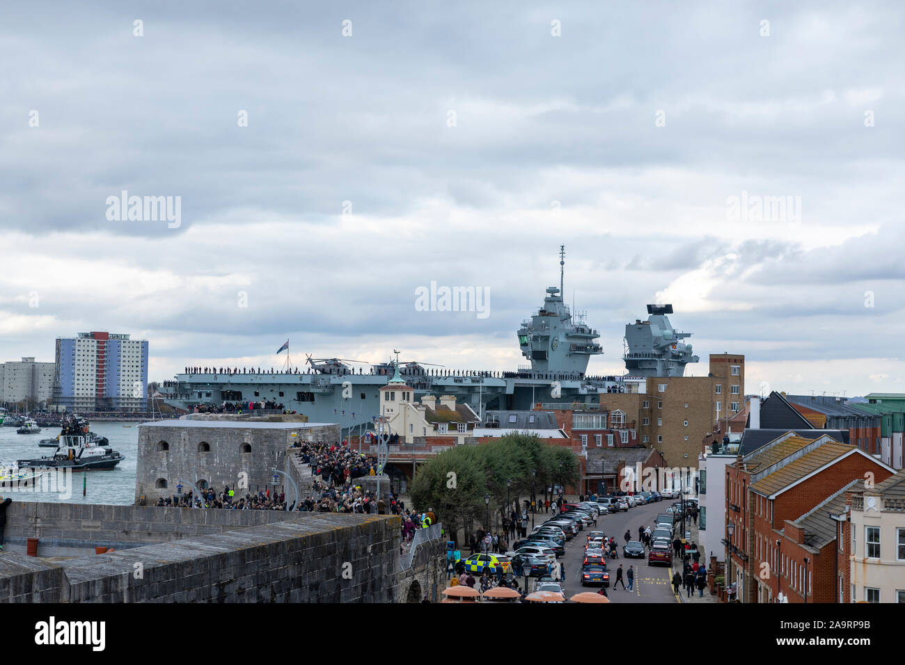 HMS Prince de Galles arrivant à Portsmouth sa nouvelle maison. La foule recueillie par une froide après-midi de novembre pour accueillir le navire de guerre massive. Banque D'Images
