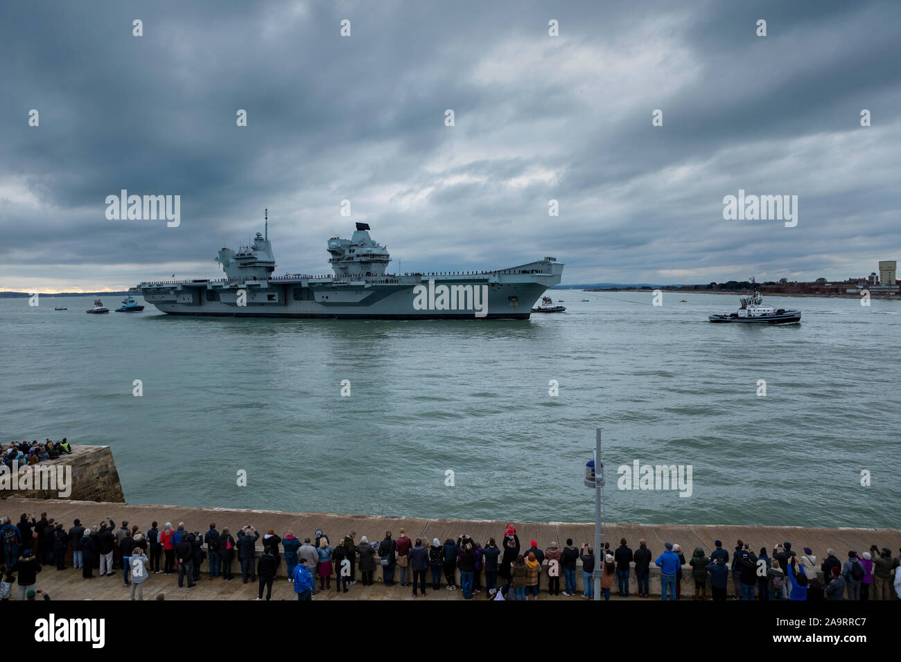 HMS Prince de Galles arrivant à Portsmouth sa nouvelle maison. La foule recueillie par une froide après-midi de novembre pour accueillir le navire de guerre massive. Banque D'Images