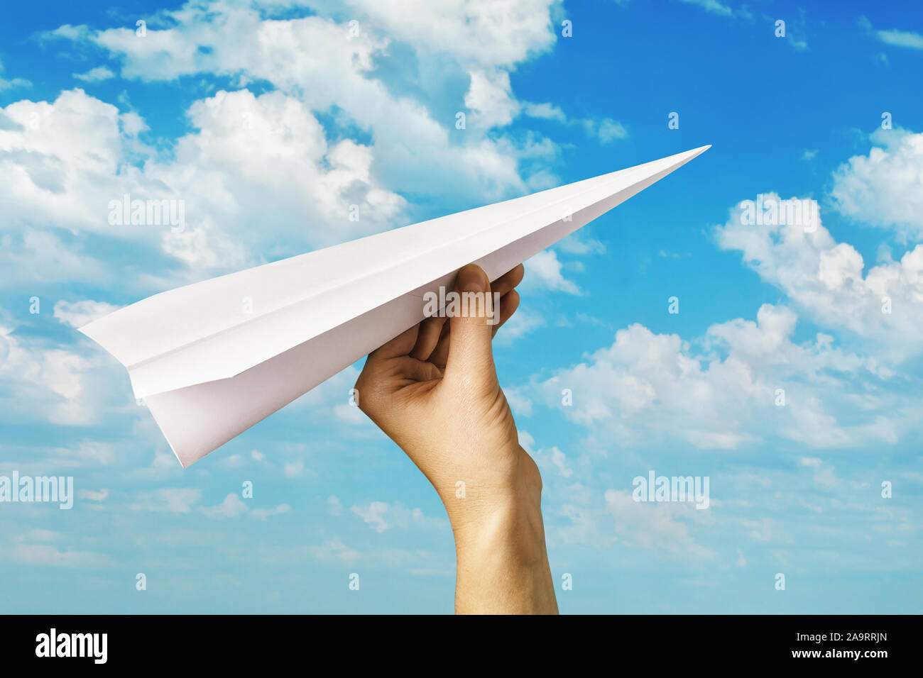 Un homme lance un avion en papier dans le ciel. La main avec un jouet avion. S'efforçant de l'avant Banque D'Images