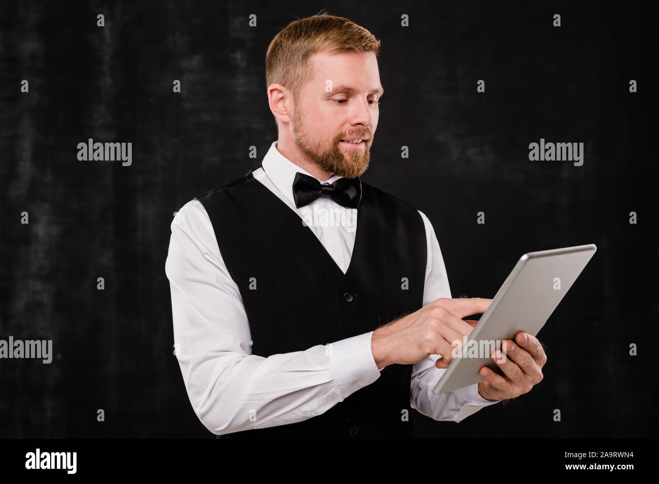 Garçon élégant du restaurant chic le défilement dans le menu lors de la recherche pour tablette Banque D'Images