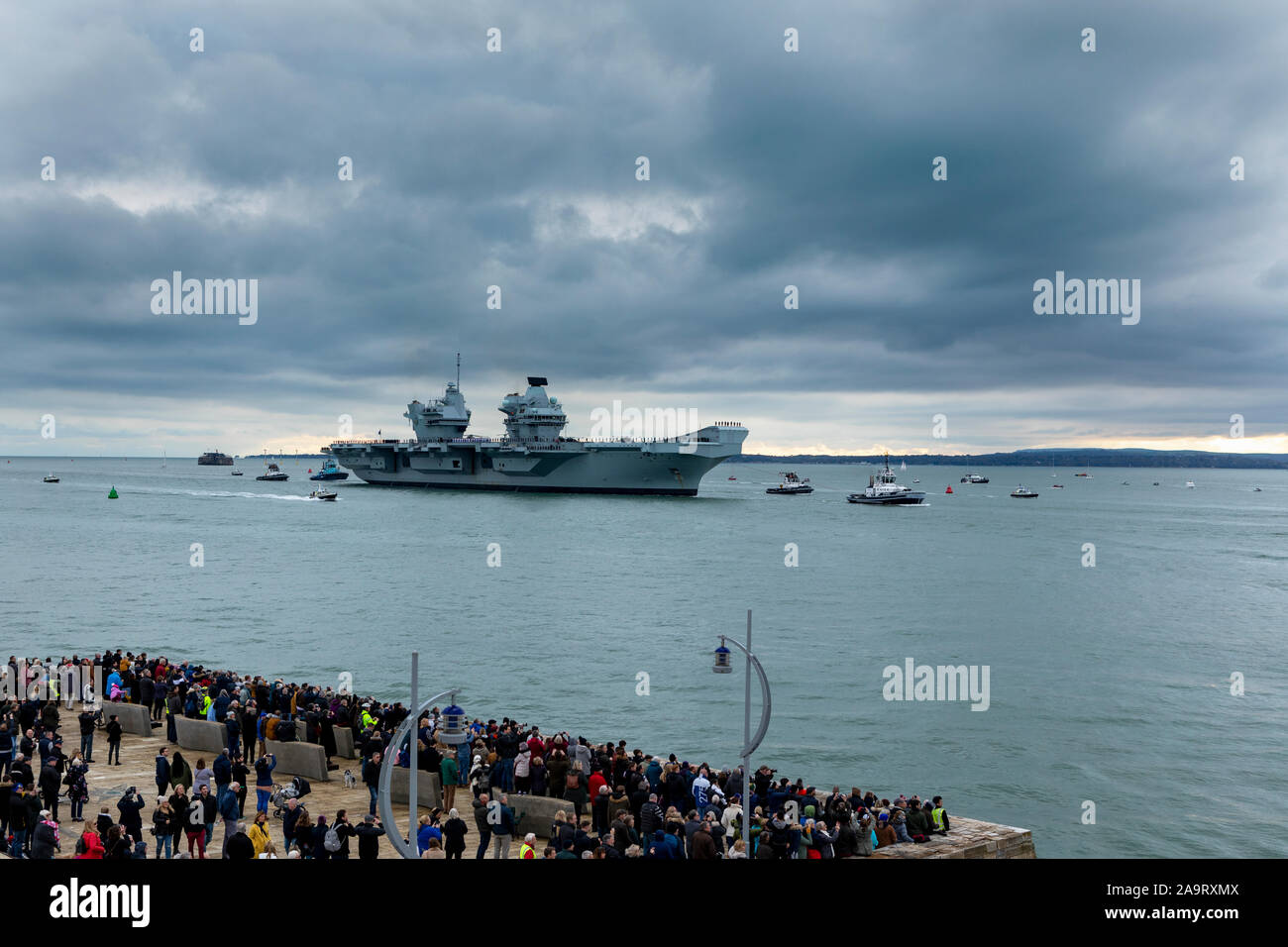 HMS Prince de Galles arrivant à Portsmouth sa nouvelle maison. La foule recueillie par une froide après-midi de novembre pour accueillir le navire de guerre massive. Banque D'Images