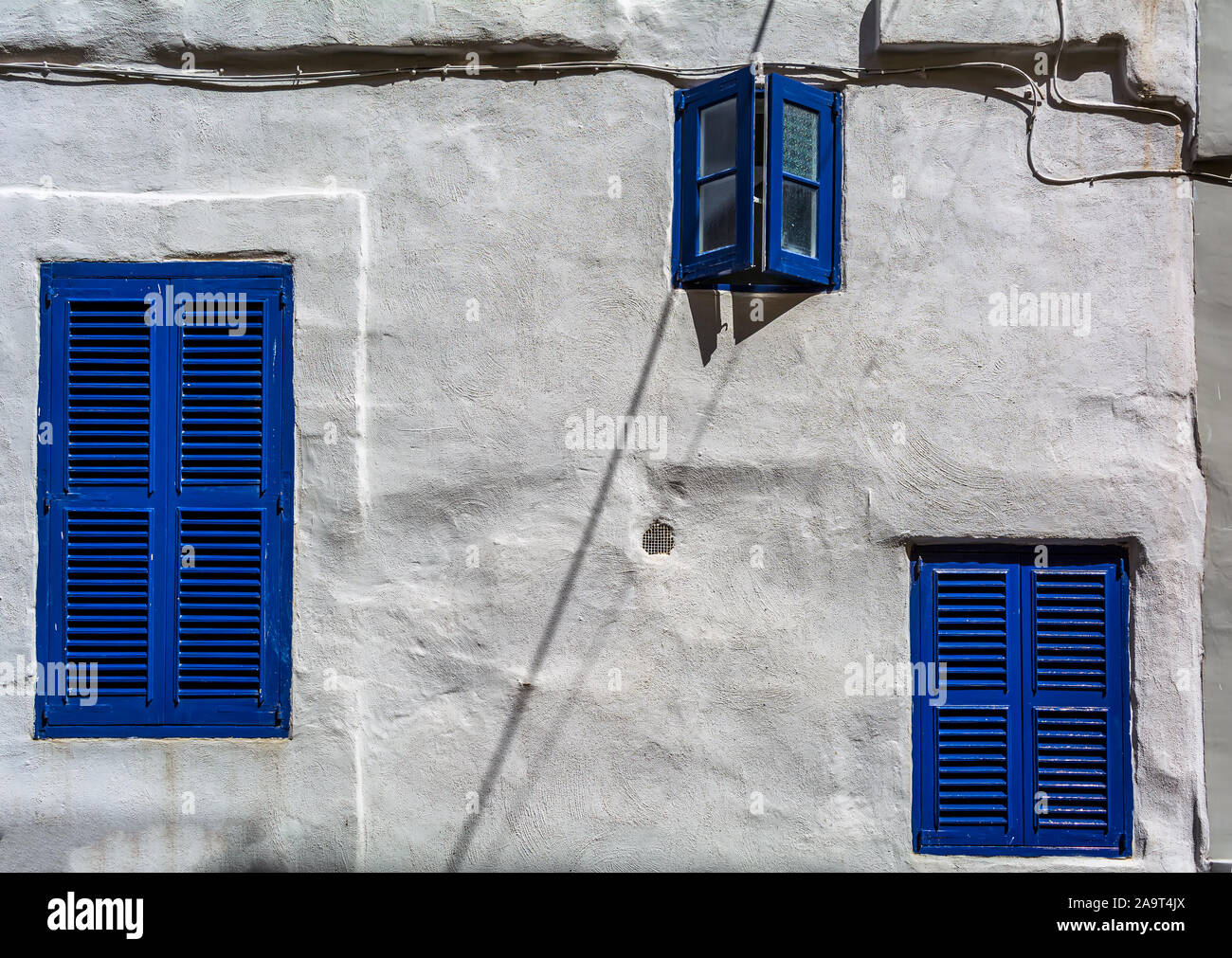 Trois fenêtres bleu marine en mur blanc Banque D'Images
