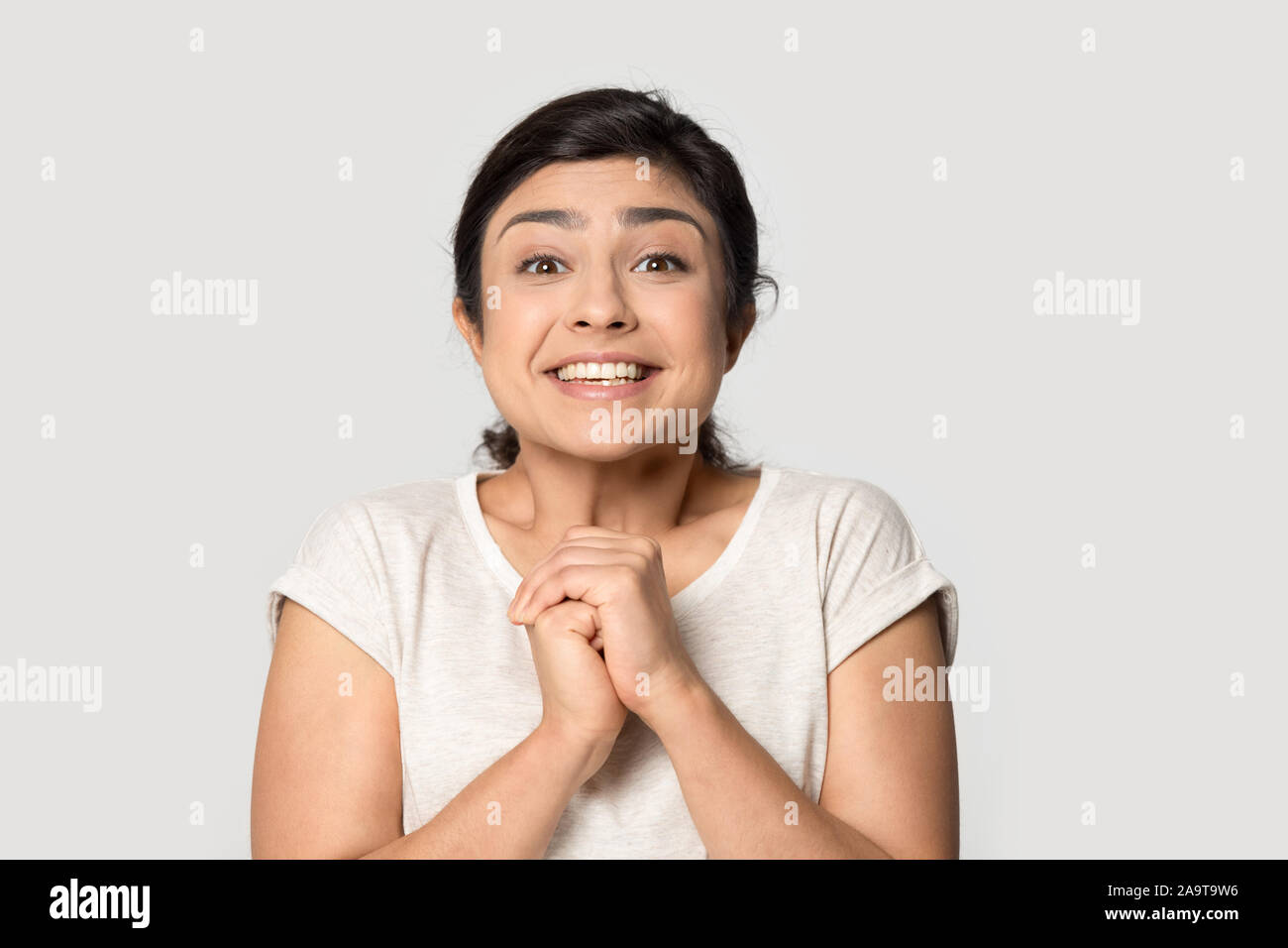 Head shot portrait smiling Indian girl joindre les mains avec l'excitation Banque D'Images