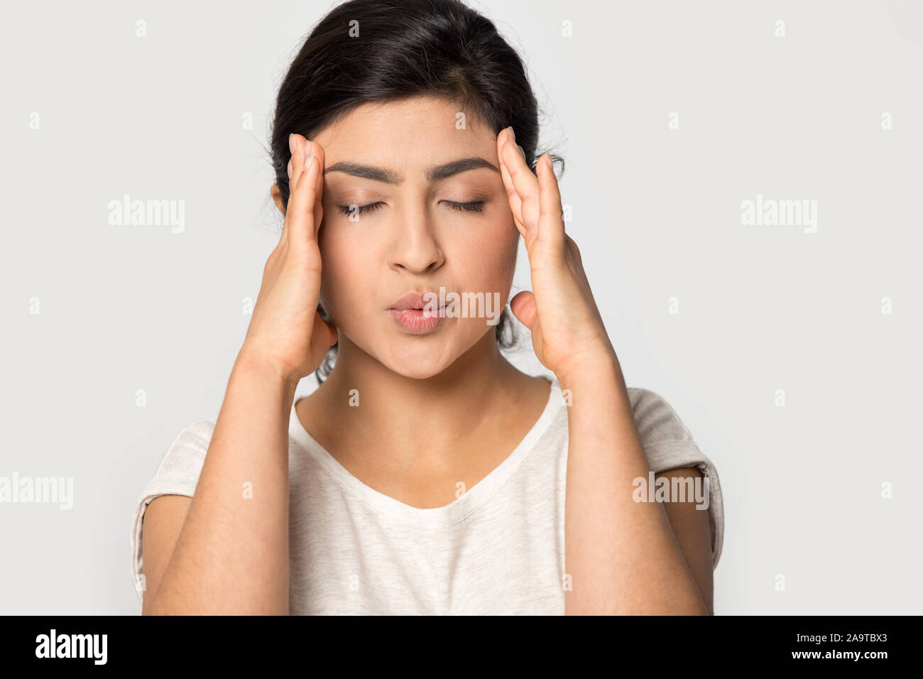 Souligné Indian girl temples massage close up, souffrant de maux de tête Banque D'Images