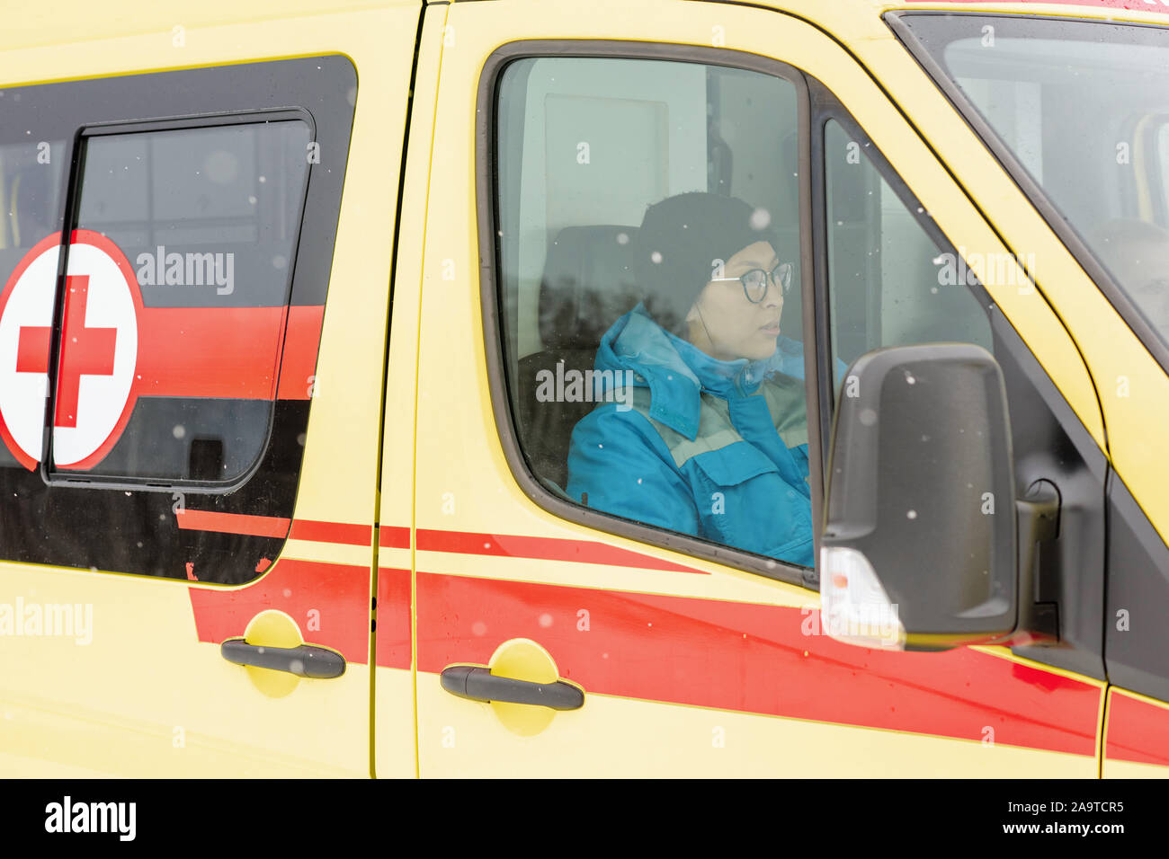 Les jeunes femmes en uniforme se dépêchant de paramédic malade en voiture ambulance Banque D'Images