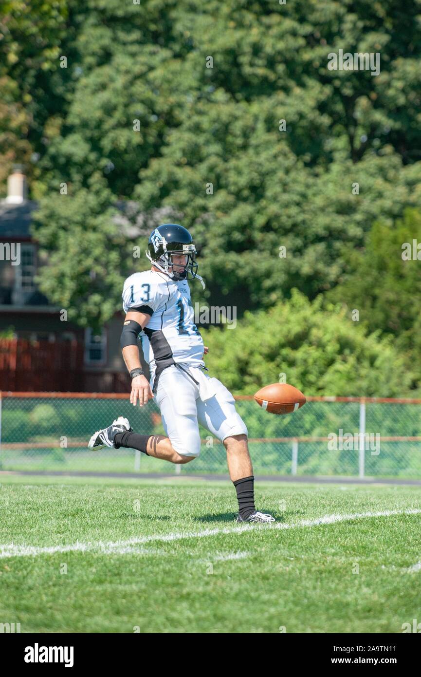 Profil de pleine longueur d'un coup de l'Université Johns Hopkins, joueur de football masculin sur une journée ensoleillée, les coups de la balle au cours de match avec Delaware Valley University, le 5 septembre 2009. À partir de la collection photographique de Homewood. () Banque D'Images