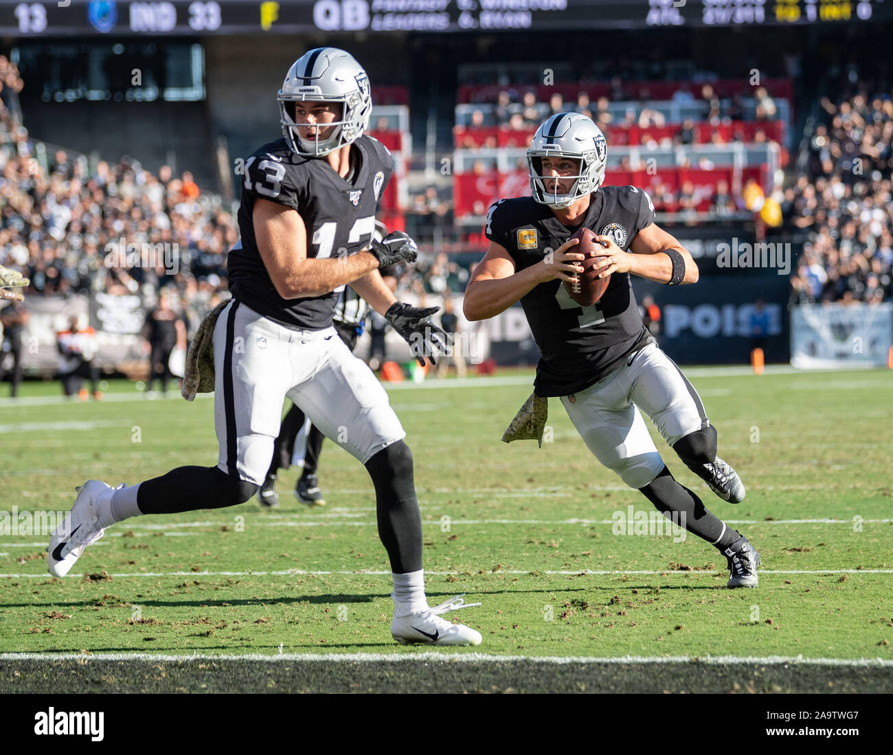 Oakland, Californie, USA. 17 novembre, 2019. Oakland Raiders quarterback Derek Carr (4) et des mains pour un touché sous la protection de Oakland Raiders wide receiver Hunter Renfrow (13), au cours d'un match de la NFL entre les Bengals de Cincinnati et l'Oakland Raiders à la Oakland Coliseum à Oakland, Californie. Valerie Shoaps/CSM/Alamy Live News Banque D'Images