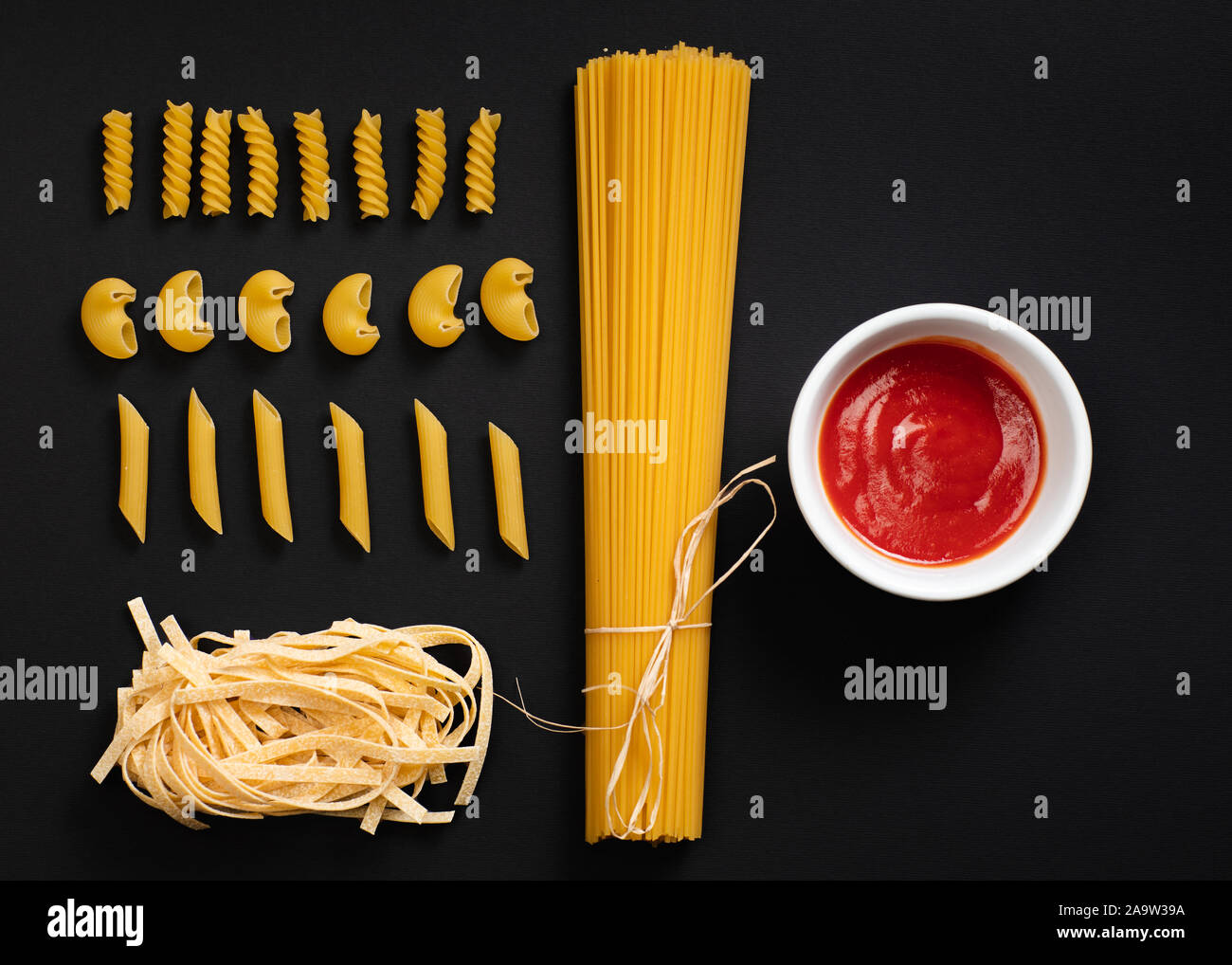 Différentes formes de pâtes et spaghettis sur fond noir. Banque D'Images