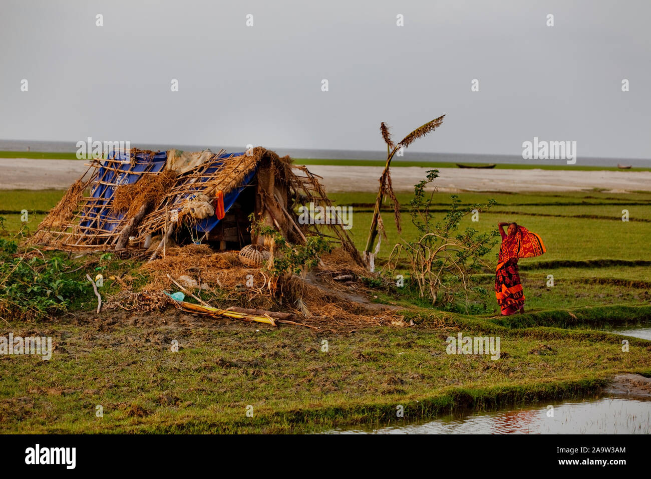 Une femme se distingue par sa maison de fortune. Elle a perdu sa maison aux pieds en raison de l'érosion de la rivière et a été faite à nouveau sans-abri par le cyclone Sidr Banque D'Images