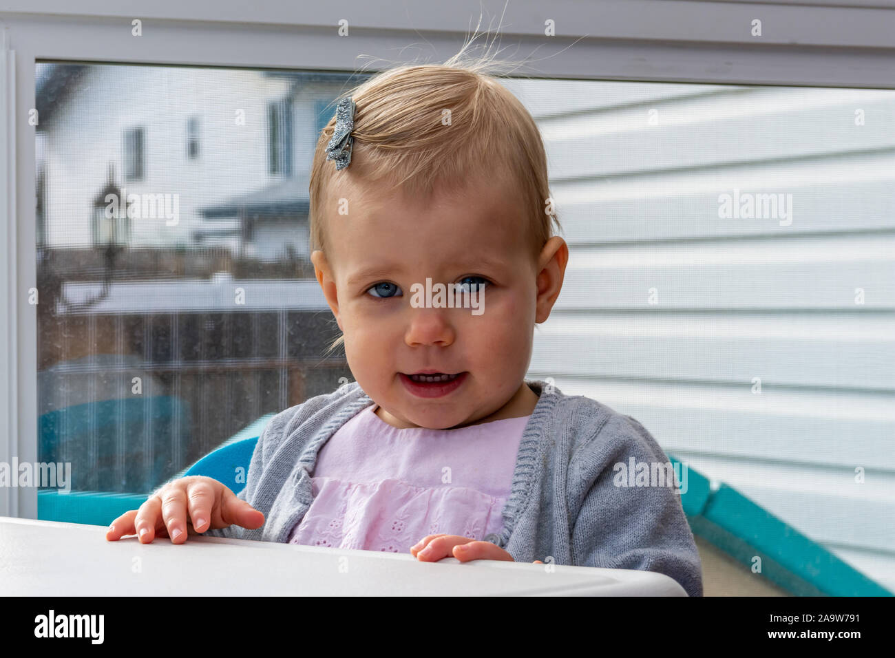 Blonde aux yeux bleus, petite fille avec un mignon, regard innocent, Close up. Banque D'Images