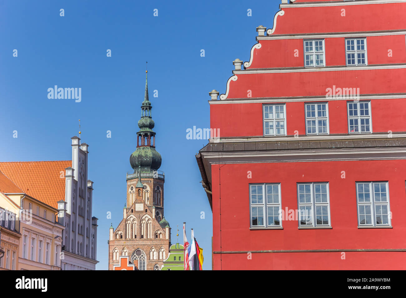 L'hôtel de ville rouge et clocher de l'église dans la ville hanséatique de Greifswald, Allemagne Banque D'Images